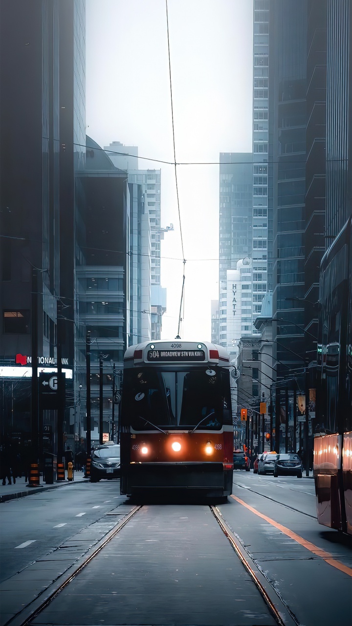 Обои здание, небоскреб, легковые автомобили, автомобильное освещение, автобус в разрешении 720x1280